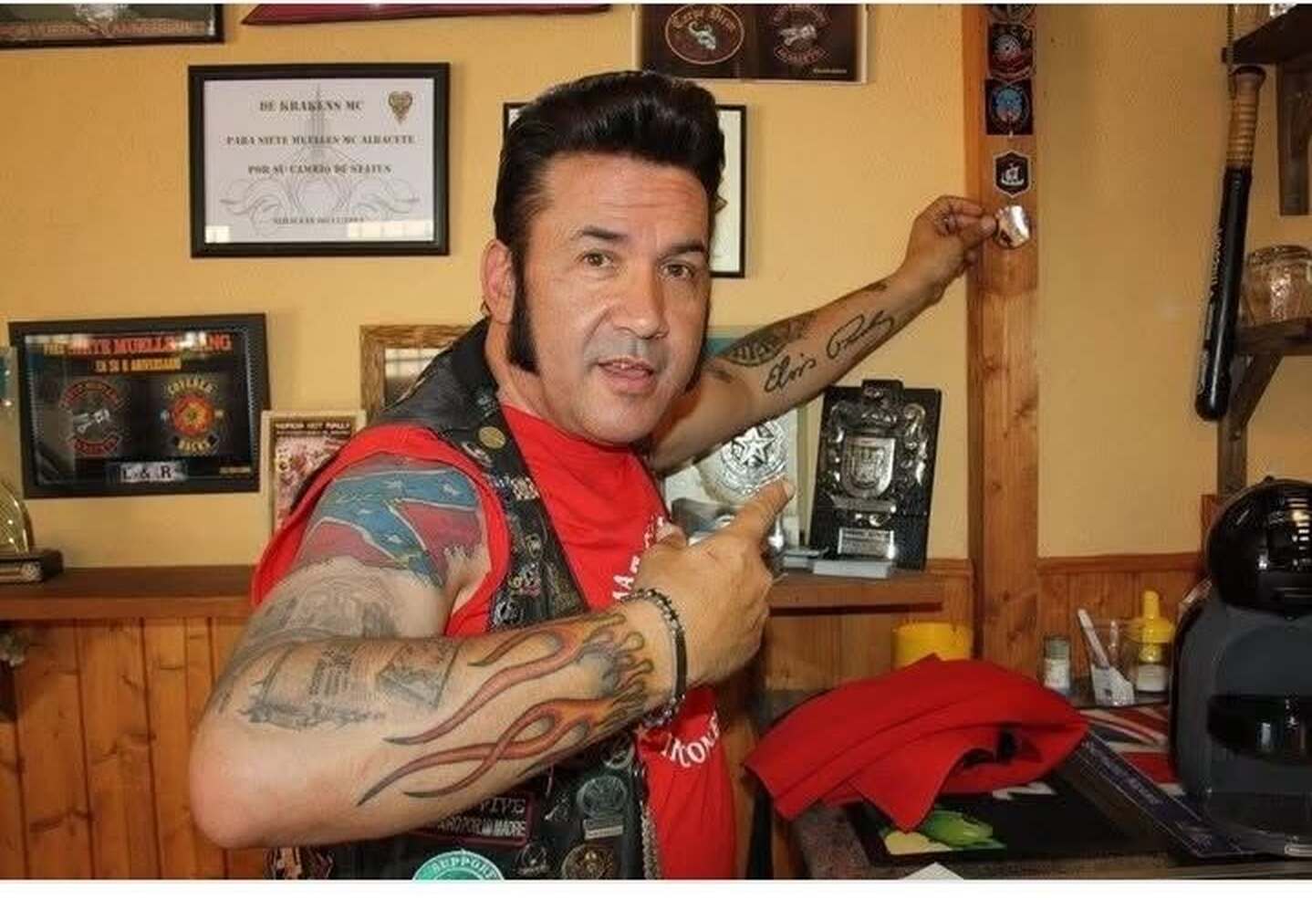 Marcos Elvis mostrando recuerdos en un local motero