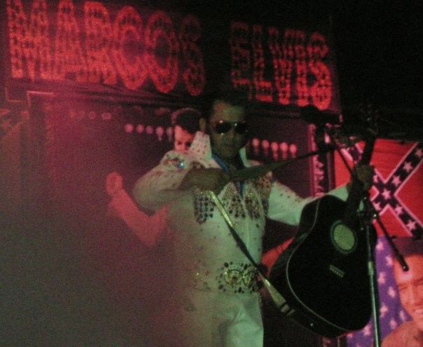 Marcos Elvis actuando ante un fondo rojo