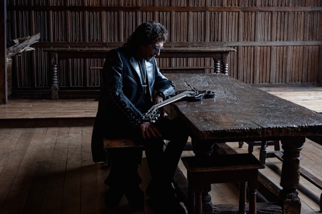 Tony Iommi sentado junto a su guitarra en la fotografía promocional de From The Dark